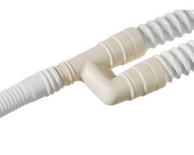 Y-kobling for kondensslanger i lys beige plast, forbinder 16mm og 18mm slanger på hvid baggrund.