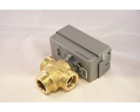 Bosch 3-vejsventil i messing ved siden af en grå styreenhed, klar til installation på varmepumpeanlæg.