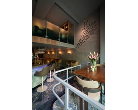 SLV LISENNE væglamper i stengrå lyser op på væggen i en moderne restaurant.