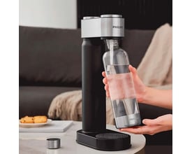 Philips sodavandsmaskine i sort med en glasflaske fyldt med vand, klar til at blive sat i maskinen.