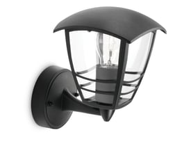 Philips Mygarden Creek væglanterne i sort metal med klart glas og synlig lyskilde, vist på en hvid baggrund.