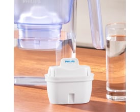 Et hvidt Philips vandkandefilter, model AWP230P6/31, placeret foran en vandkande og et glas med vand.