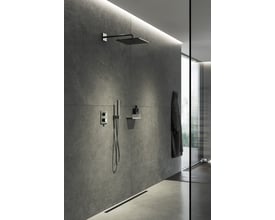 Grohe Grohtherm Cube brusesystem installeret i et moderne badeværelse med grå stenfliser og glasvæg.