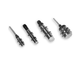 Carlo Gavazzi EI1808TBOSS induktiv aftaster med M18-gevind og 8 mm tasteafstand, vist blandt cylindriske sensorer set skråt.