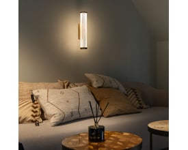 SLV QUIMERA WL væglampe monteret på en væg over en sofa, illuminerer rummet med en blød og dæmpbar atmosfære.