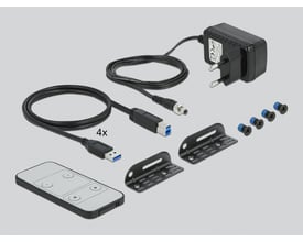 Medfølgende tilbehør til Delock KVM switch, inkluderer strømforsyning, USB 3.0 kabler, fjernbetjening og monteringsbeslag.