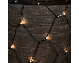 Konstsmide lyskæde net med varm hvid LED monteret på en mørk, tekstureret overflade, tæt på.