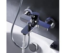 AM.PM X-Joy S kararmatur i krom, der løber med vand på en hvid badekar og mørk væg.