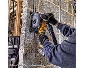 DeWalt Flexvolt rillefræser DCG200NT-XJ i brug til at skære en kanal i en betonvæg, med støvudsugning tilkoblet.