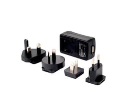 3M Peltor FR08 vægkontakt med USB-port og strømadapter vist sammen med forskellige stikadaptere.