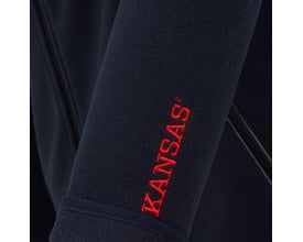 Detaljeret billede af Kansas Evolve Fleece Jakke i marineblå, viser rødt broderet Kansas logo på venstre ærme.