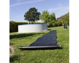 Swim & Fun solvarmepanel på 6,1 x 0,6 meter ligger rullet ud på græsset ved siden af en pool på en solskinsdag.