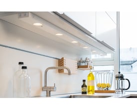 SG Armaturen Chef LED armatur monteret i et moderne køkken under overskabene, lyser op arbejdsfladen.