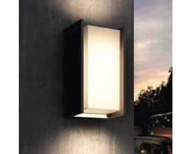 Philips Hue Turaco udendørs væglampe i antracit lyser varmt hvidt på en udvendig væg ved skumring.
