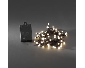 Konstsmide lyskæde med 80 varm hvide LED-lys og opal kugler samlet og placeret ved siden af det sorte batteridæksel på en grå baggrund.