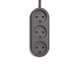 Nærbillede af ColorCable Experimental stikdåsens tre udtag på en mørkegrå baggrund, med et smilende ansigt motiv.
