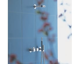 Vola 1-grebsblander med keramisk ventilenhed monteret på blå fliser, vist med en brusehoved holder ovenfor.