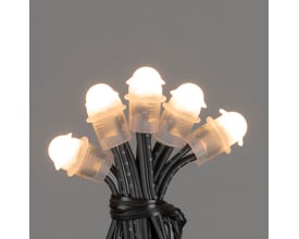 Nærbillede af 100 Konstsmide amber LED-lys på en sort ledning, der udsender et varmt, hyggeligt skær.