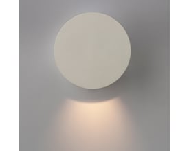 ANTIDARK Dot W120 væglampe i hvid, med lys der skaber en blød glød på den grå væg.