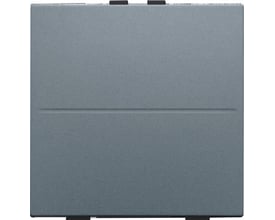 Niko trådløs 2-tryks tangent i stålgrå farve med en diskret vandret linje på fronten og sorte monteringsdetaljer øverst og nederst.