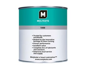 Molykote 1000 pasta i en 1 kg metaldåse med grøn og grå etikette, der beskriver produktets fordele og Dow Cornings arv.
