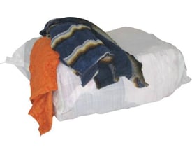 En stor hvid plastikpose med kulørte frotteklude i forskellige farver, herunder orange og blå med striber, klar til brug.