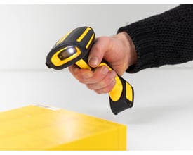 DeLock industriel stregkodescanner i gul og sort holder over en gul pakke, klar til scanning.