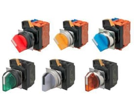 Omron A22NS vælgere i forskellige farver (rød, orange, blå, grøn, grå, mørk orange) med 22 mm diameter og sort plast bezel vist side om side.