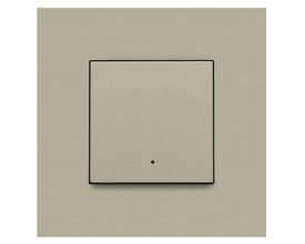 Niko Home Control 1-tryk i champagnefarve med sort kant, viser den integrerede LED-indikator i midten af knappen.