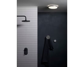 Astro 0587 Denia loftarmatur i krom med opalglas skærm monteret på mørkt loft, med detaljer af et moderne badeværelsesmiljø.