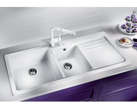 Blanco Naya 8 S UX køkkenvask i hvid komposit, 116x50 cm, med to kummer, hane og integreret afløbsbakke monteret i en hvid bordplade.