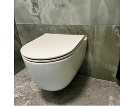 Monteret hvidt Cassøe Silent toiletsæde på en væghængt toiletkumme, indrammet af moderne badeværelsesfliser.