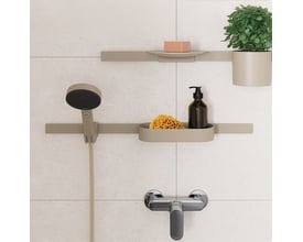 Hansgrohe brusehylder i beige mat, viser monterede hylder med sæbe, plante, svamp og sæbedispenser i et moderne badeværelsesmiljø.