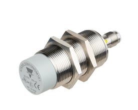 Carlo Gavazzi ICS E1 induktiv sensor i M30-størrelse med rustfrit stålhus og grå front, set skråt fra siden.