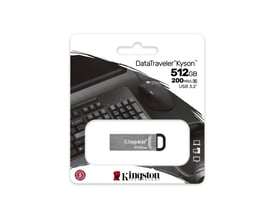 Kingston DataTraveler Kyson 512GB USB 3.2 Gen 1 flashdrev i sølvfarvet metalkabinet, vist i sin blisterpakke med baggrund af computerudstyr.