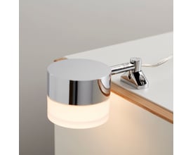 Loevschall Garonne spejllampe i krom monteret på en hvid bordplade, viser lampens lysende skærm.