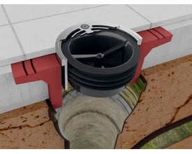 Green Drain selvrensende membran-lugtlukke i sort plast, monteret i et badeværelsesgulv med synlig afløbsrør og jord.