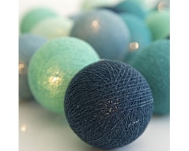 Nærbillede af Irislights lyskæde med stofkugler i forskellige blå og grønne farver, der viser den detaljerede tekstur.