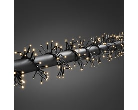 Konstsmide cluster lyskæde med 1152 varm hvide LED'er på sort kabel viklet omkring et mørkt rør.