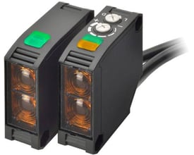 Omron E3JK-2010B fotoelektrisk sensor med firkantet legeme, der viser to enheder med orange linser og røde LED-indikatorer.