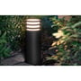Philips Hue Lucca udendørs piedestal lyser langs en havesti omgivet af planter.
