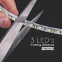 Nærbillede af V-TAC LED lyslist der klippes med en saks, hvilket illustrerer skæremuligheden hver 3. LED.