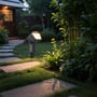V-TAC Pro solcellelampe placeret i en have på et græsdække, belyst ved siden af en stensti om aftenen.