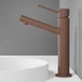 Scandtap Vector Medium håndvaskbatteri i rustfrit stål med rustlook, 1-grebs betjening, monteret på hvid bordplade med grå væg.