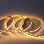 En Ansell Lighting H-Cell LED strip med 3000K lys ruller sig ud, viser tæt på de mange små lysdioder og 3M klæbestribe på bagsiden.