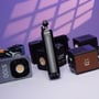 Batterigrebet til 100 W kompakt studiebelysning står mellem forskellige lamper og lysudstyr.