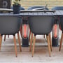 Mensa Heating IMUS terrassevarmere placeret under et havebord med stole, viser effektiv opvarmning fra lav højde på en træterrasse.
