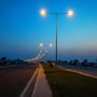 V-TAC LED-gadelygte på 150 W ses i brug langs en vej med tændte gadelygter i skumringen.