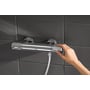 GROHE Grohtherm 1000 Performance brusearmatur monteret på mørke fliser, mens et greb betjenes.