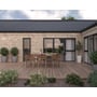 Plastmo Arkitekt tagrende i sort stål monteret på moderne hus med træterrasse og havemøbler.